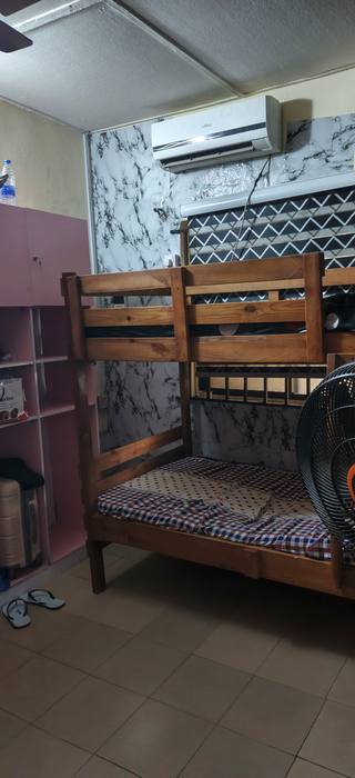 VIP bed space: single-occupancy wooden bunk bed with an air conditioner above it