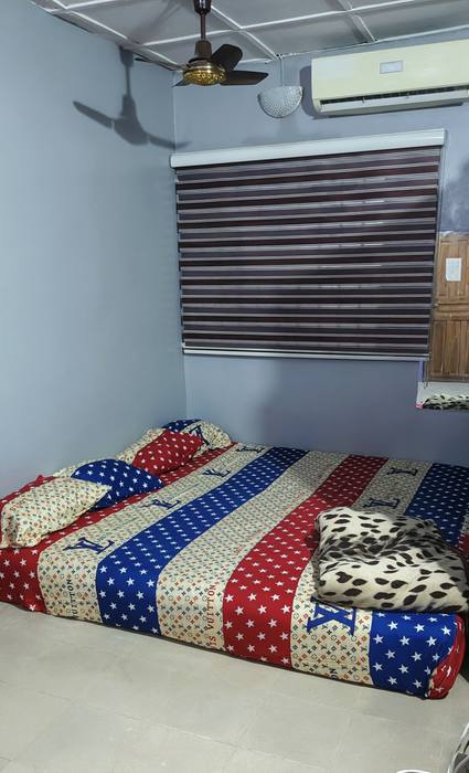 Regular room: bright grey-blue room with a large mattress, star-print bedding, air conditioner, ceiling fan and window blinds